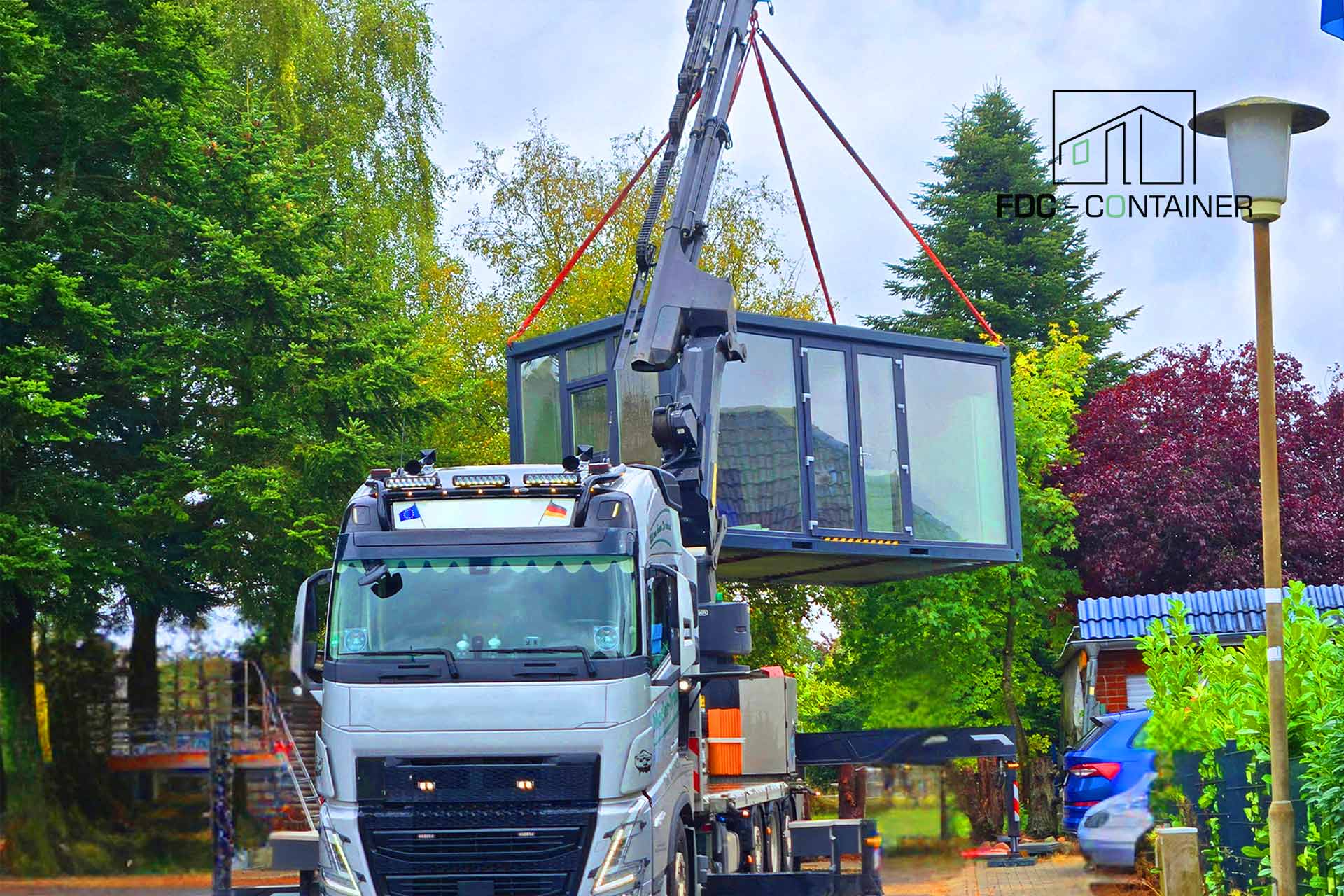 Montage eines Modulcontainers mit Kran während des Transports und der Positionierung FDC Container