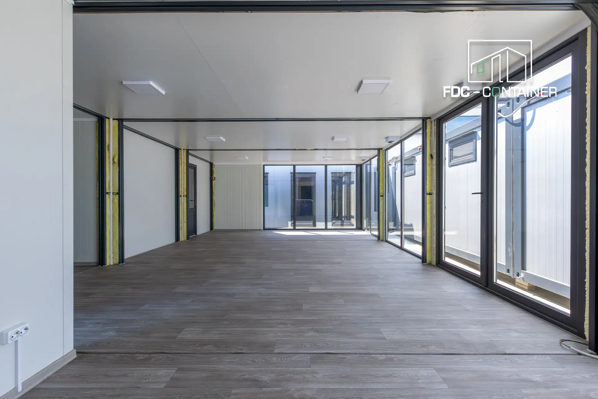 Bürocontainer innen offenes Großraumbüro mit Glastrennwand in Parkettoptik – FDC Container Bürocontainer innen offenes Großraumbüro mit Glastrennwand in Parkettoptik – FDC Container