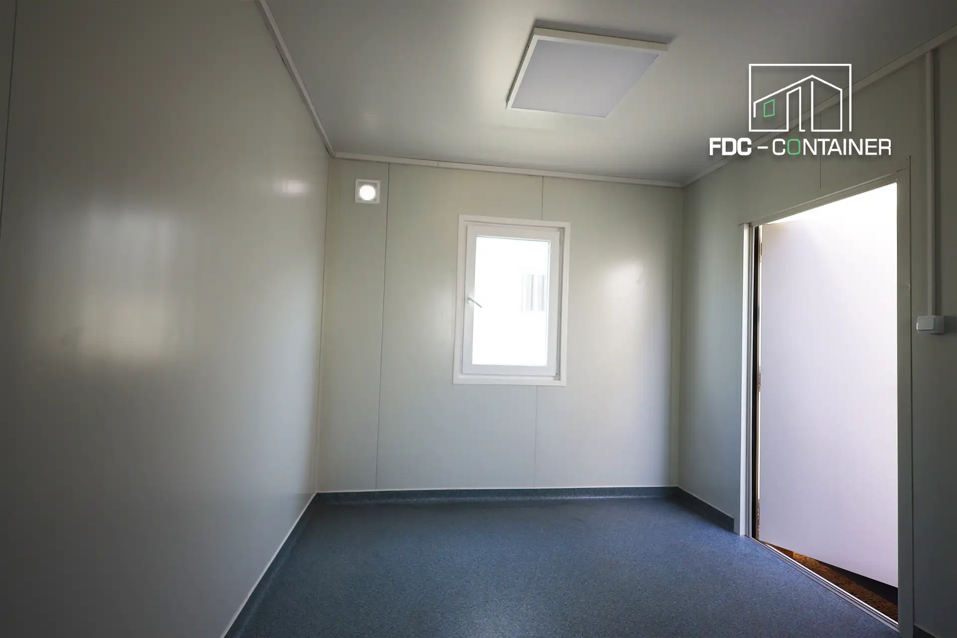 Büroraum mit Fenster, offener Tür und grauem PVC-Boden im Container – FDC Container Büroraum mit Fenster, offener Tür und grauem PVC-Boden im Container – FDC Container