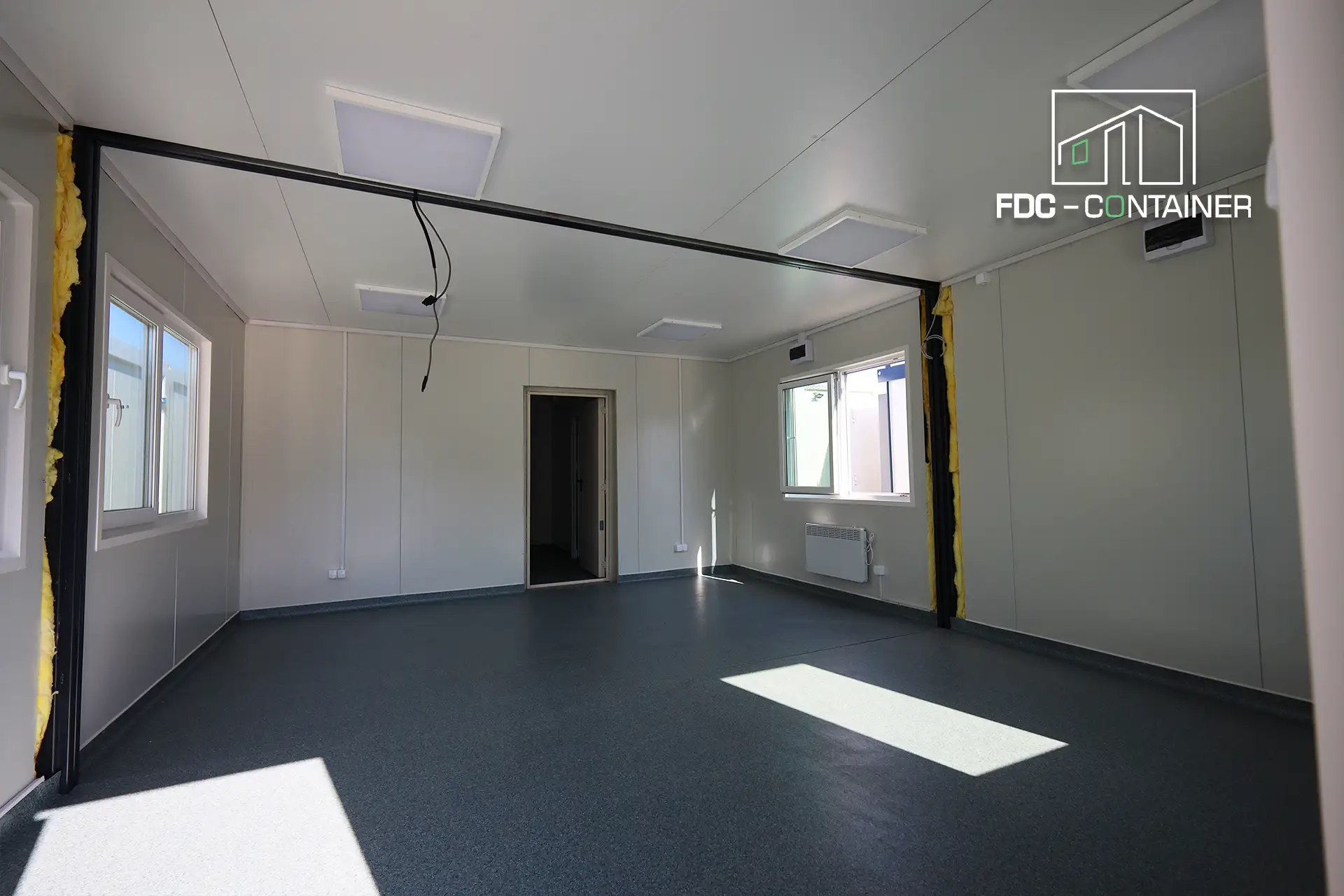 Heller Büroraum im Baustellencontainer mit Fenster und Tür, Innenansicht – FDC Container Heller Büroraum im Baustellencontainer mit Fenster und Tür, Innenansicht – FDC Container