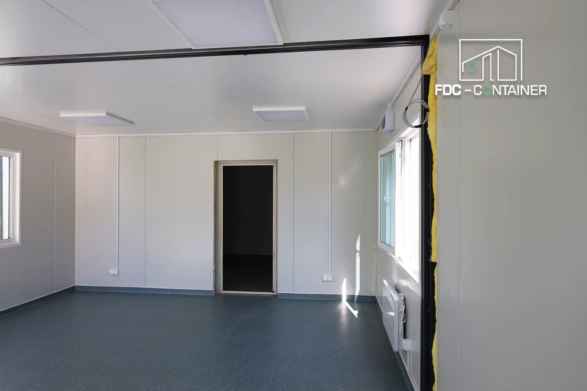 Innenraum Baustellencontainer mit weißen Wänden, Tür und grauem PVC-Boden – FDC Container Innenraum Baustellencontainer mit weißen Wänden, Tür und grauem PVC-Boden – FDC Container