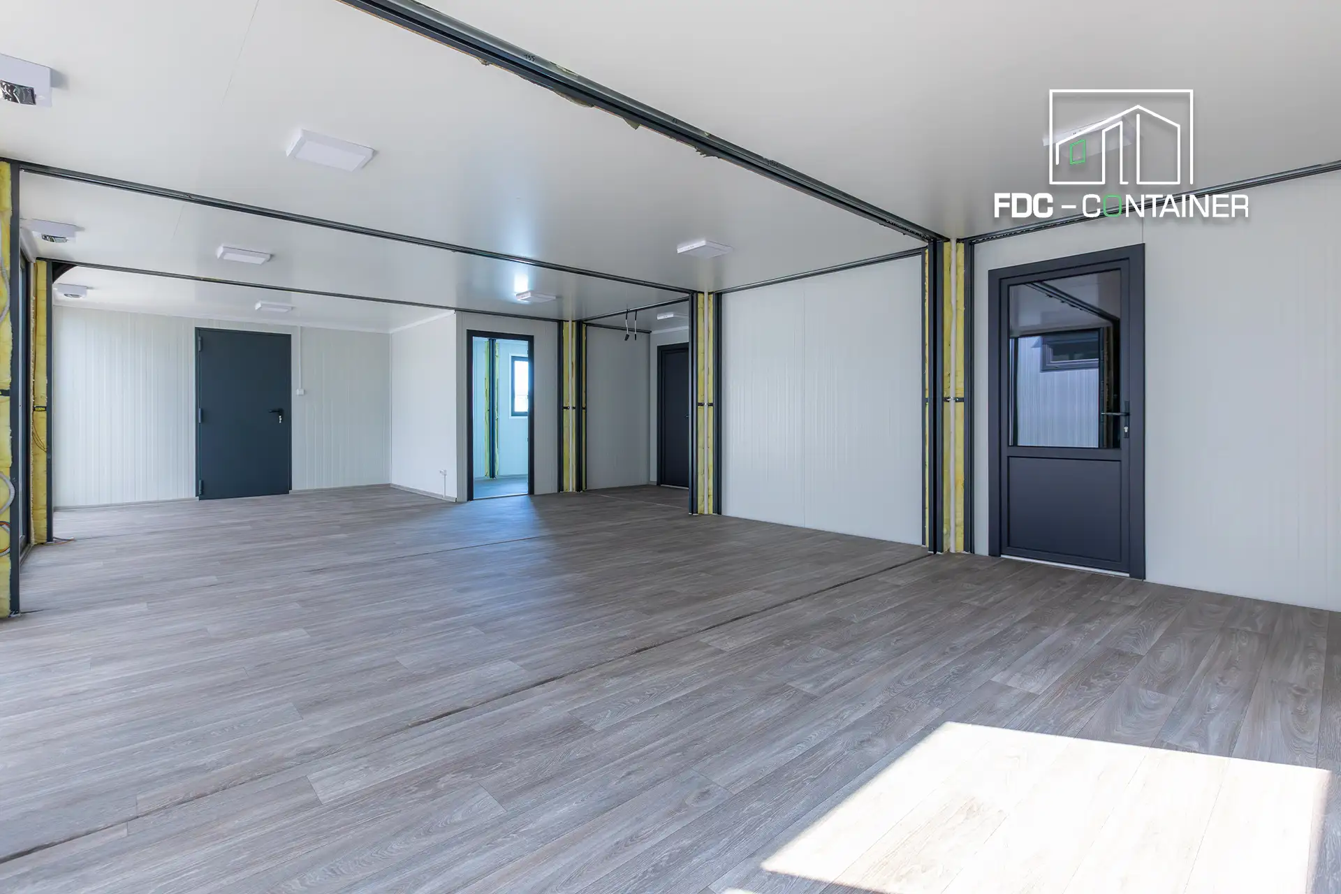 Innenraum Bürocontaineranlage mit weißen Wänden und Boden in Parkettoptik – FDC Container Innenraum Bürocontaineranlage mit weißen Wänden und Boden in Parkettoptik – FDC Container