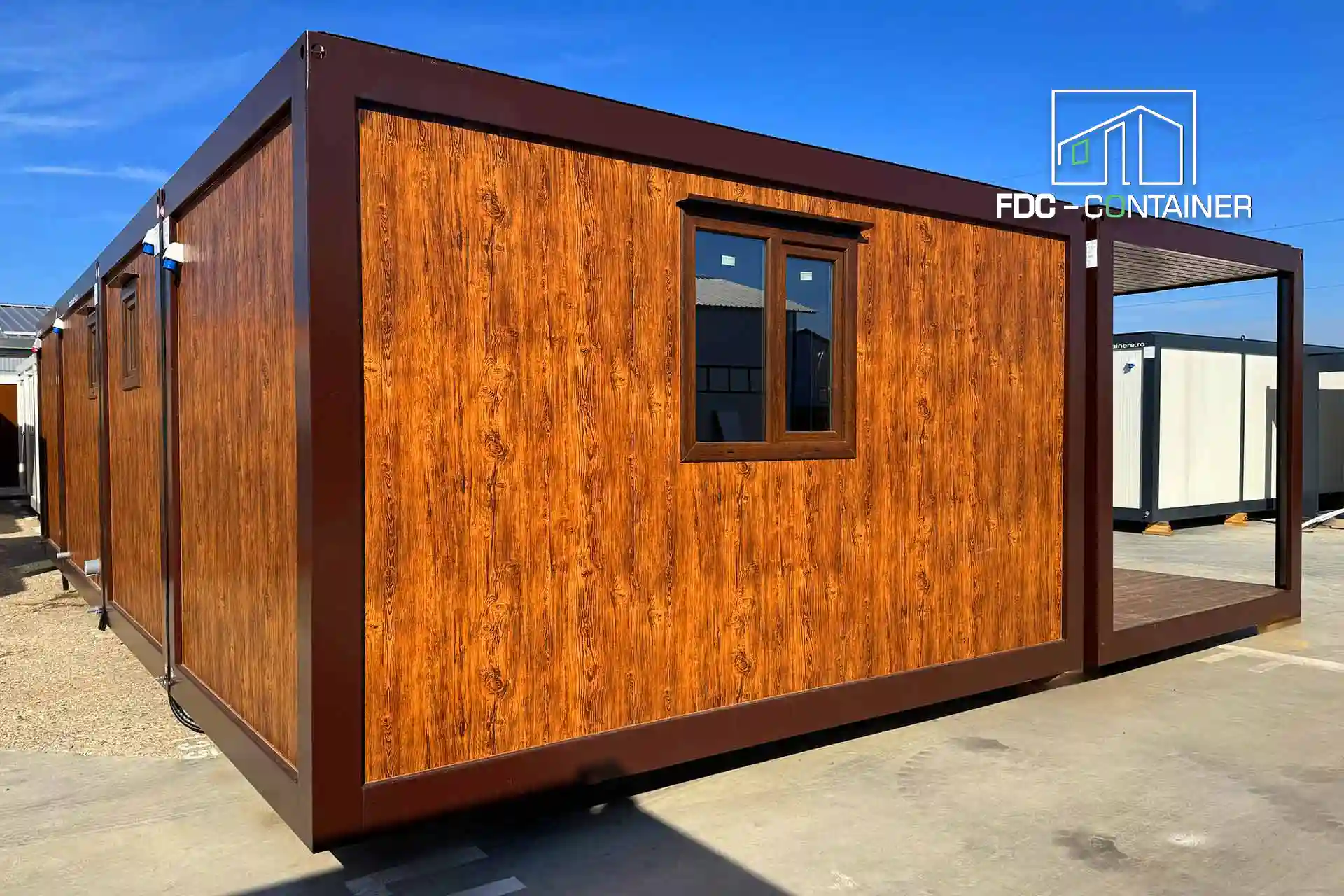 Modularer Container mit Außenverkleidung in Holzoptik, brauner Metallkonstruktion, Fenster und seitlich überdachter Terrasse - FDC Container