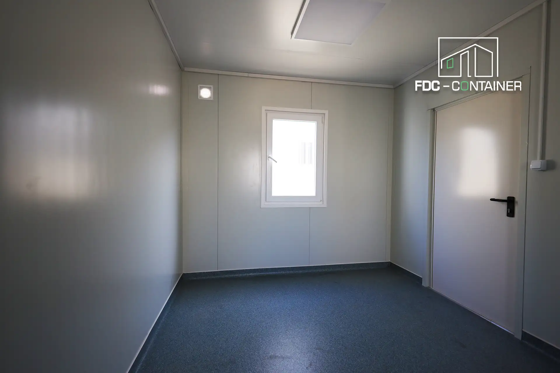 Raum im Baustellencontainer mit Fenster und weißer Tür, Innenansicht – FDC Container Raum im Baustellencontainer mit Fenster und weißer Tür, Innenansicht – FDC Container