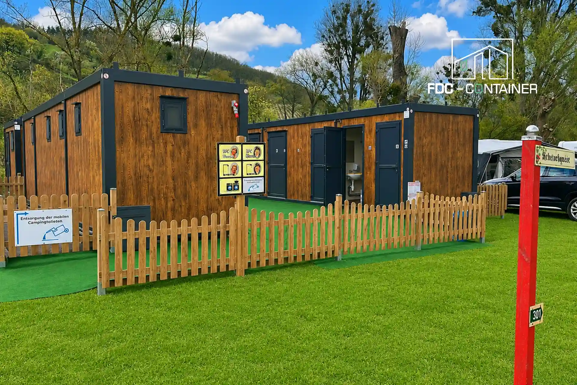 Sanitärcontainer fürs Camping auf dem Campingplatz mit Holzzaun außen – FDC Container Sanitärcontainer fürs Camping auf dem Campingplatz mit Holzzaun außen – FDC Container
