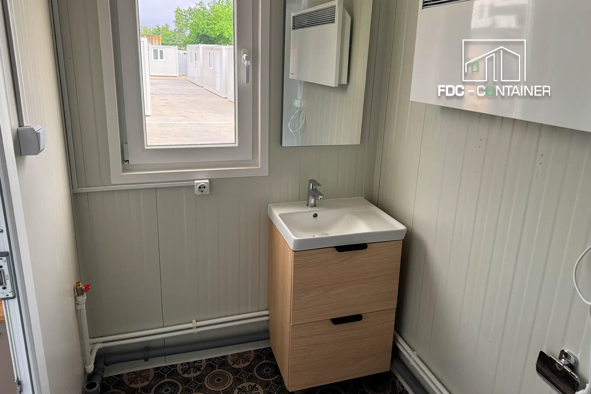Waschbecken mit Holzunterschrank und Spiegel im Bad des Containers – FDC Container Waschbecken mit Holzunterschrank und Spiegel im Bad des Containers – FDC Container
