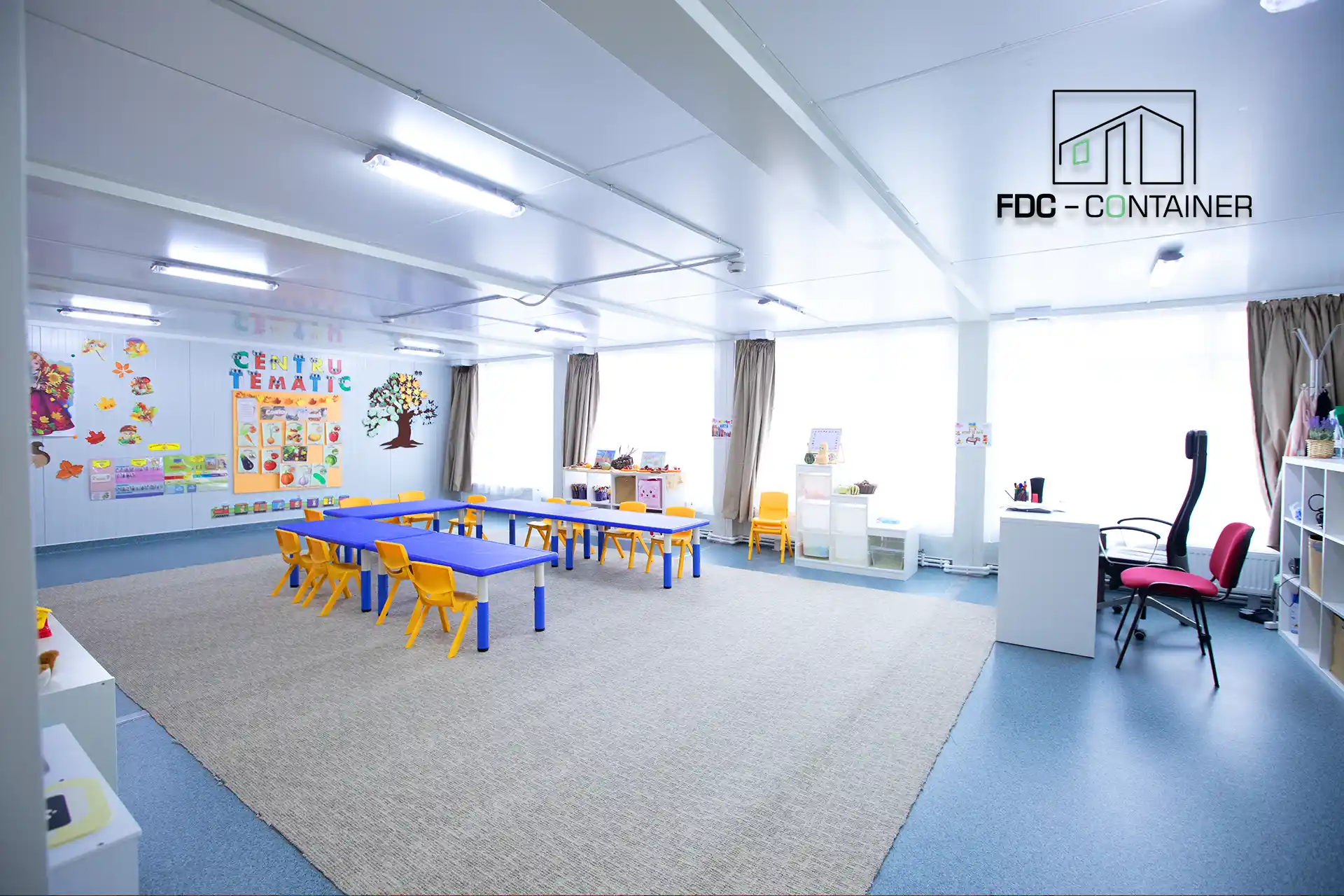 Heller Innenraum einer aus Containern realisierten Cluster School mit großen Fenstern und moderner Raumaufteilung - FDC Container