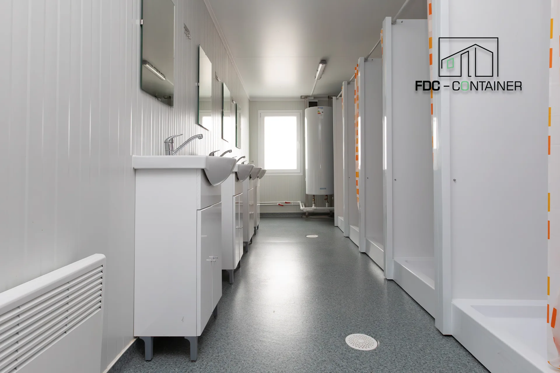 Innenraum eines Sanitärcontainers mit Waschbecken, Spiegeln, Warmwasserspeicher und getrennten Kabinen – FDC Container Innenraum eines Sanitärcontainers mit Waschbecken, Spiegeln, Warmwasserspeicher und getrennten Kabinen - FDC Container