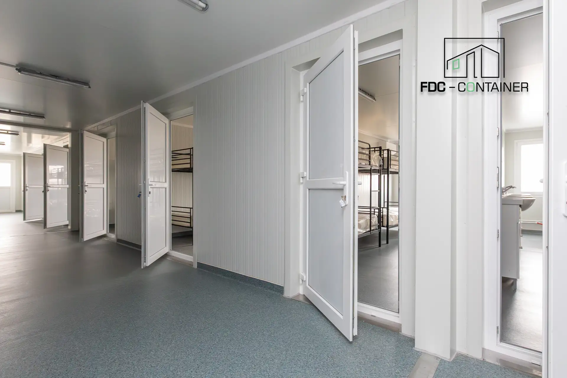 Innenraum eines modularen Unterkunftscontainers für Baustellen mit mehreren Schlafräumen und Etagenbetten - FDC Container